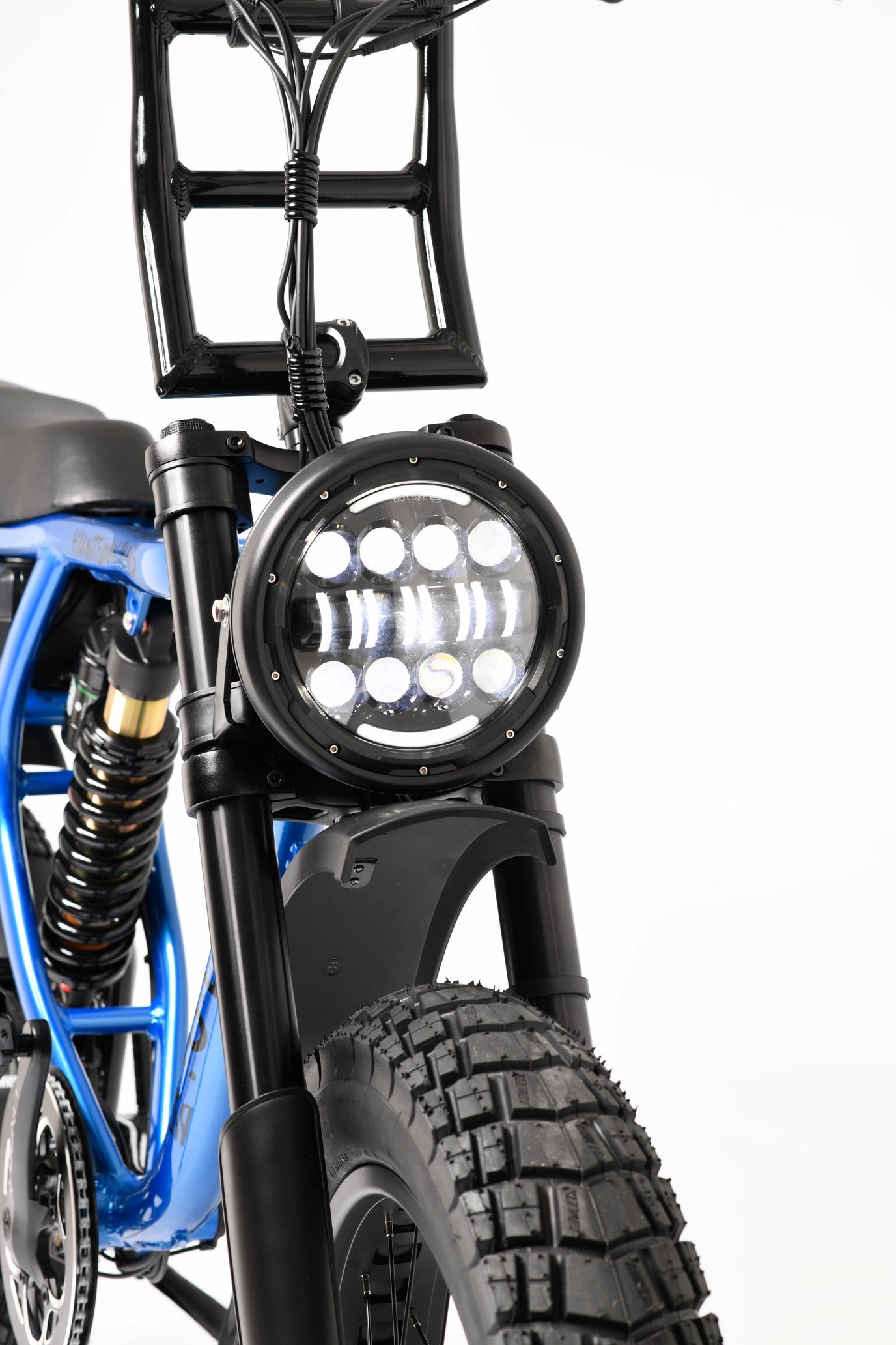 Close-up of an electric bike headlight and suspension system on a white background