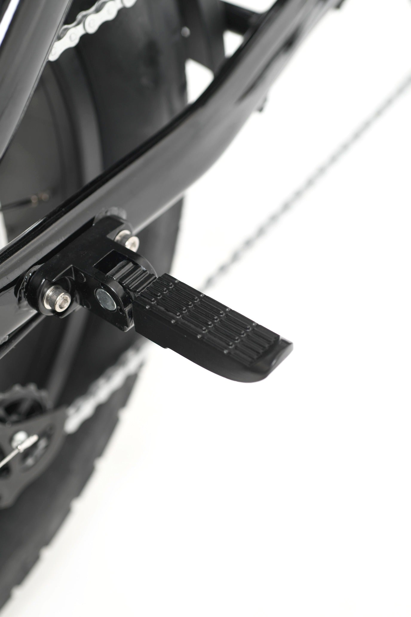 Close-up of a bicycle foot pegs and chain mechanism on a white background