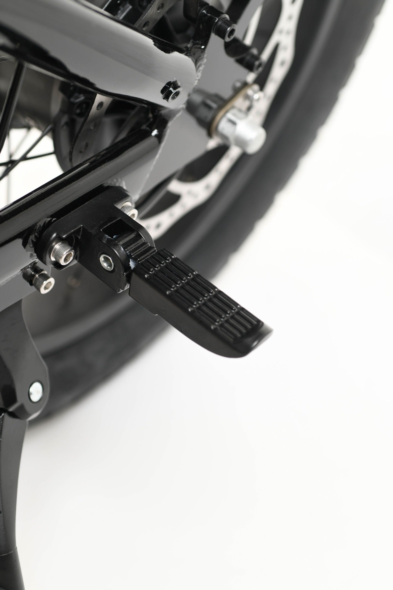Close-up of an electric bike foot peg on a white background